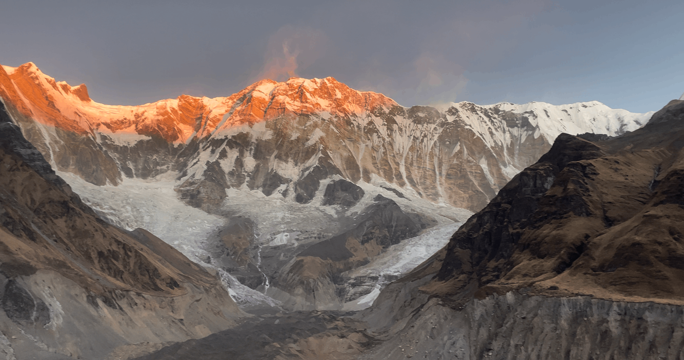 Glowing golden sunset casting warm light over Mount Annapurna I in the Himalayas