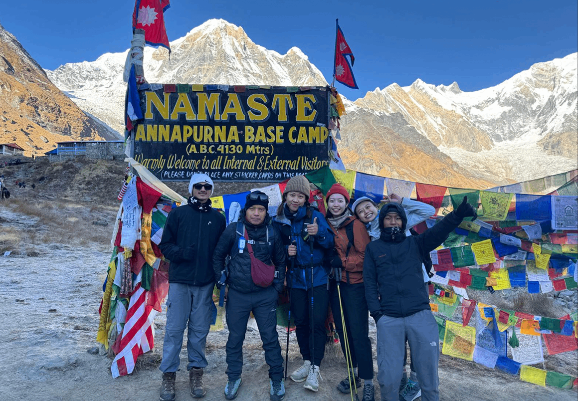 Bold Himalaya trekking team standing at Annapurna Base Camp, ready to descend after completing the journey